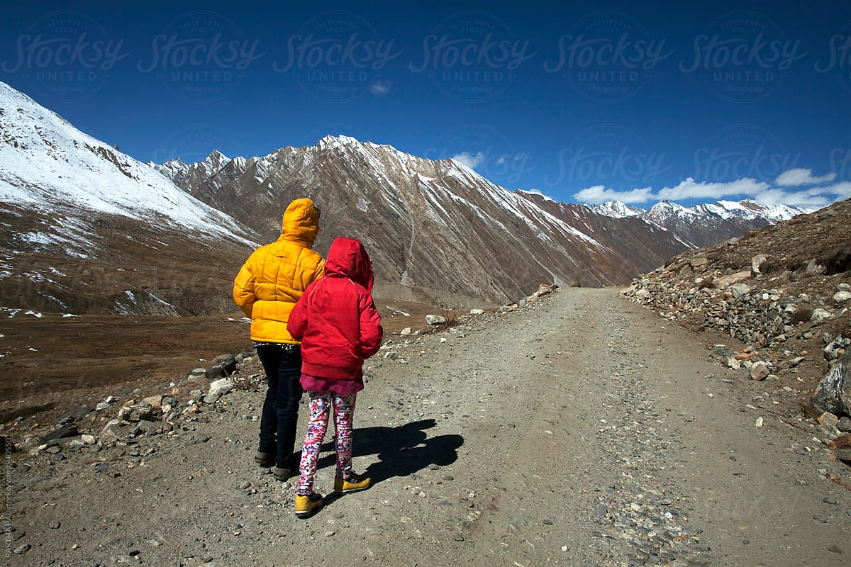 Mother and daughter walking through a high altitude mountain path