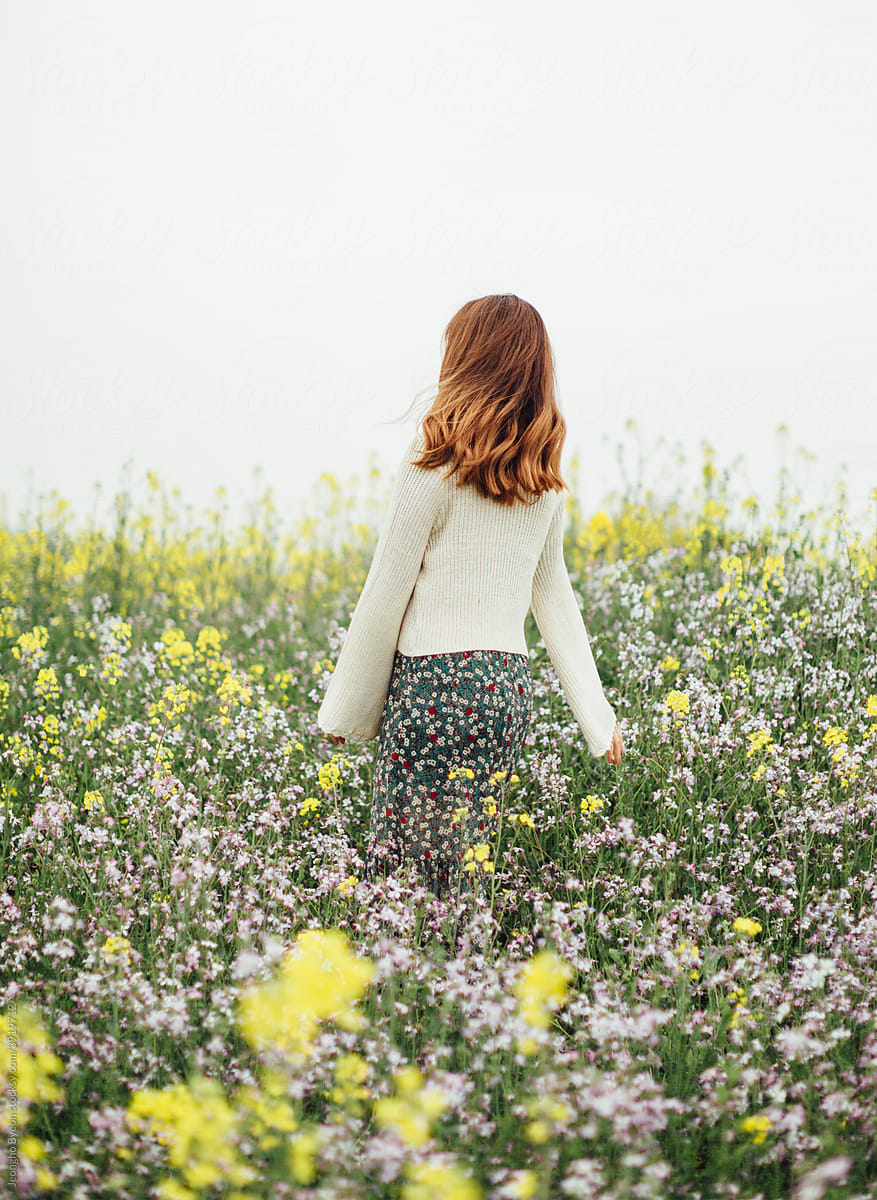 A woman standing in a flower field.