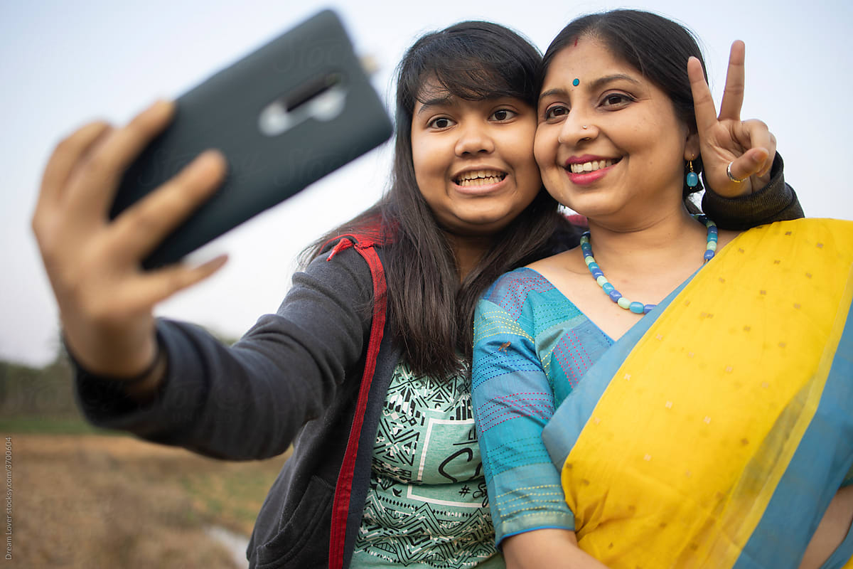 Happy Indian women and girls in saris taking selfie stock photo