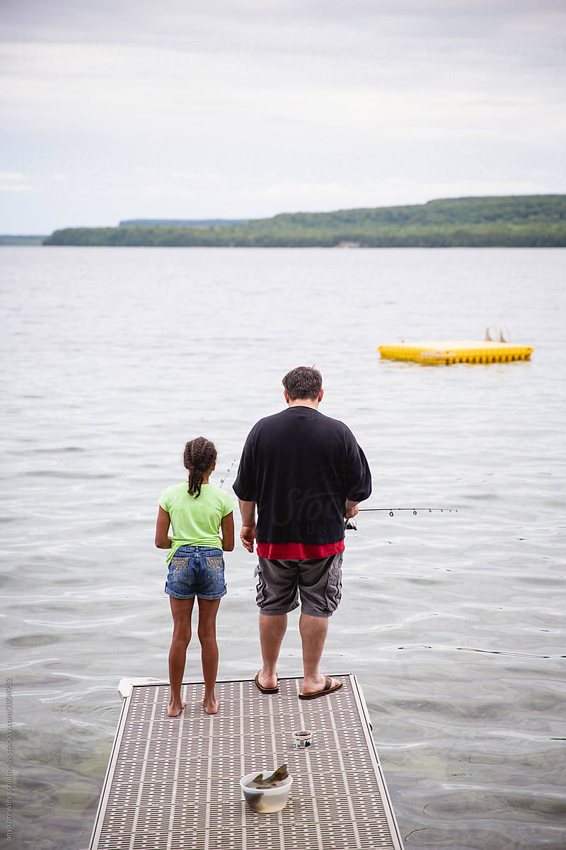 Father and daughter fishing at the end of a dock