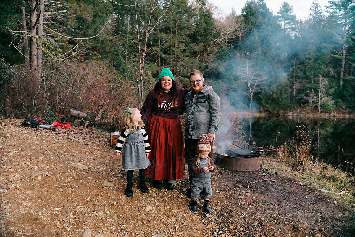 portrait of family of 4 by a camp fire on a fall evening