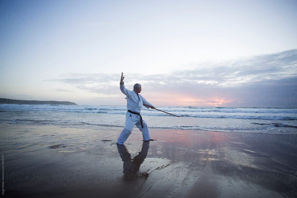 Karate Master training alone on beach.
