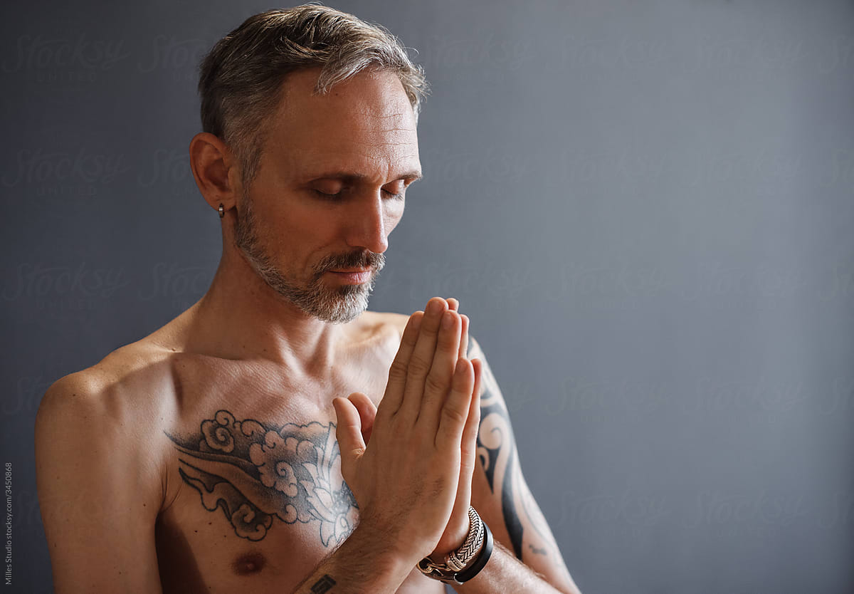 Bearded man praying during yoga lesson