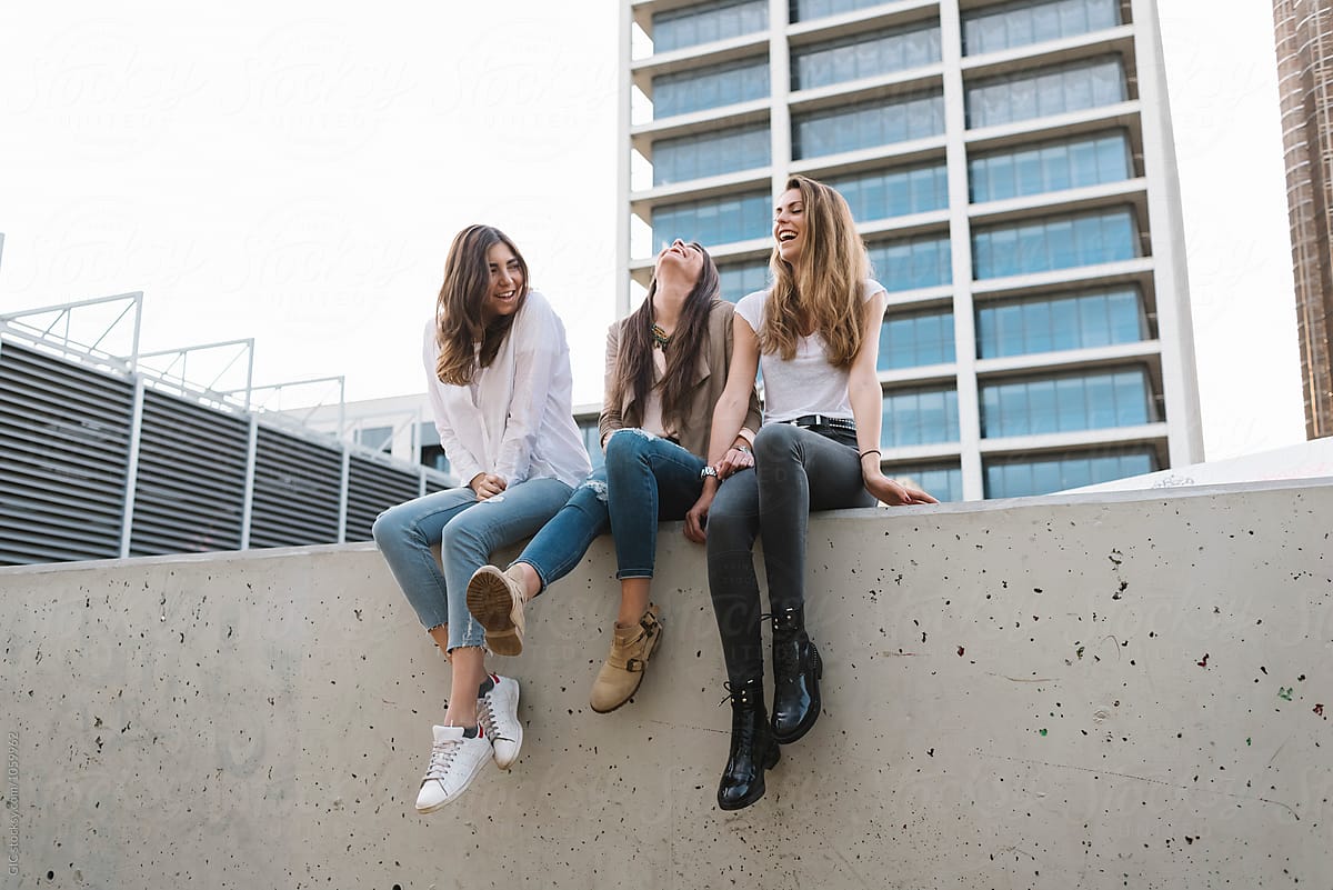 Three happy girl friends having fun in the city