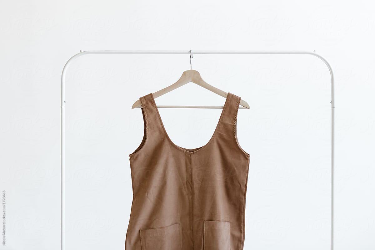 sleeveless garment hanging from minimal white clothing rack