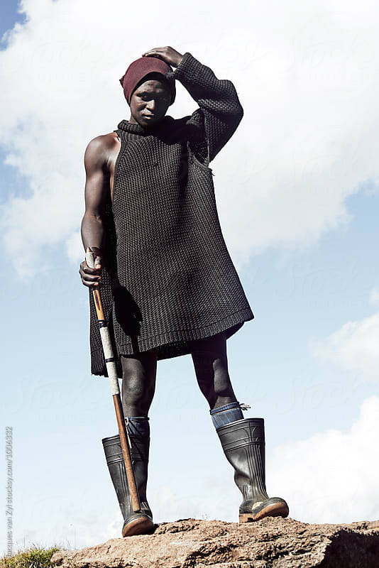 Young black Basotho shepherd in traditional clothes.