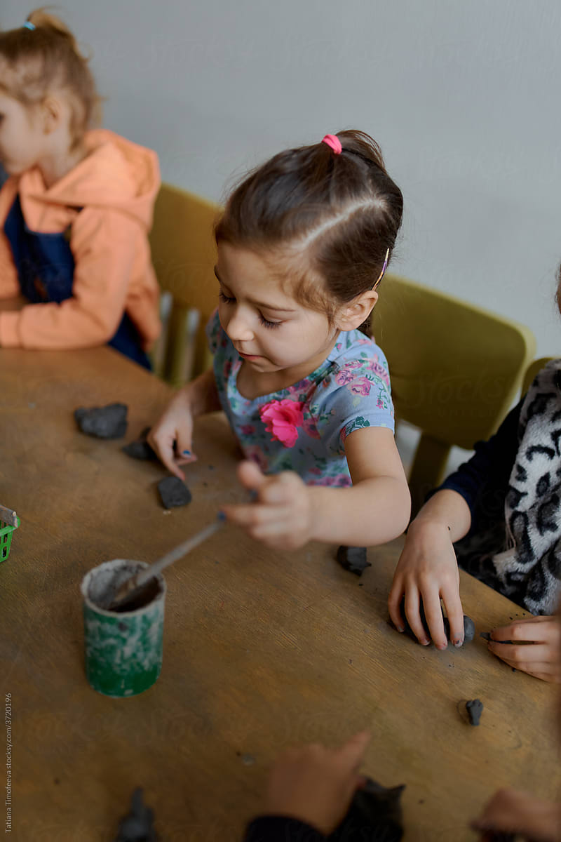 group of 5 year old preschool children in an art school learn to sculpt from clay