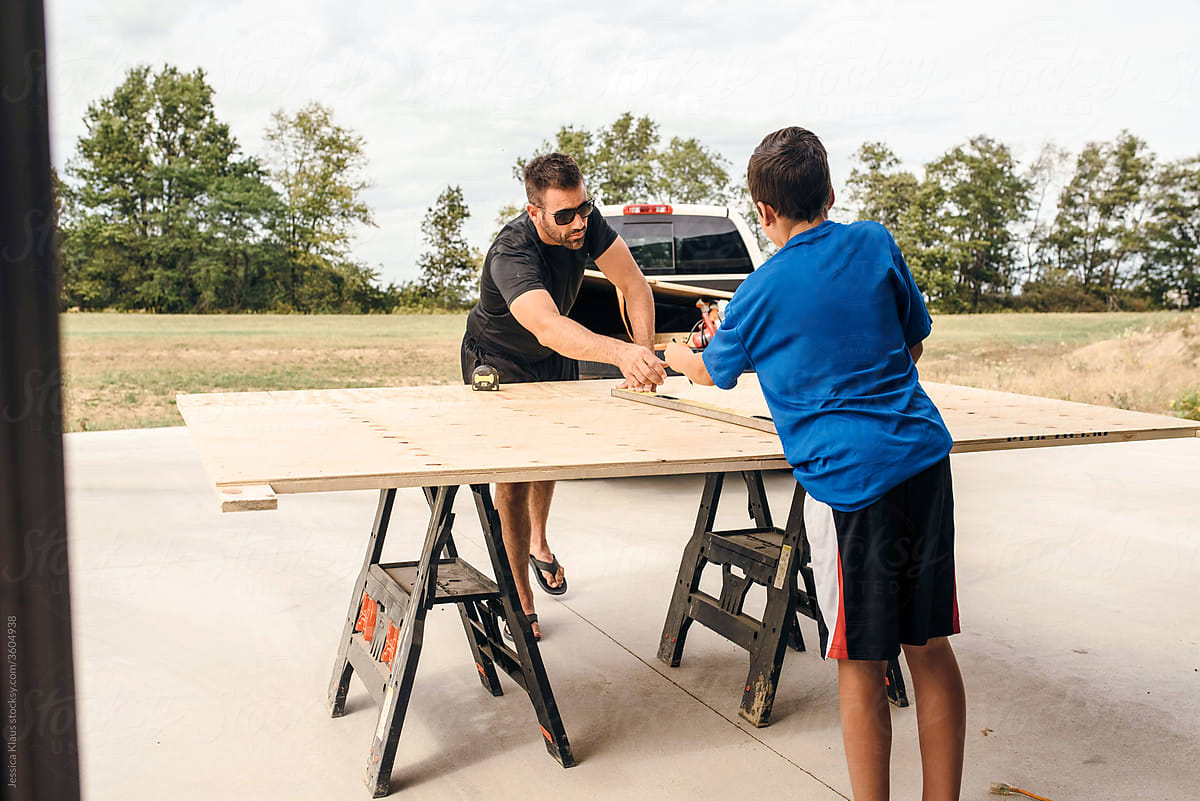 Dad working on a woodworking project with the help of his son.