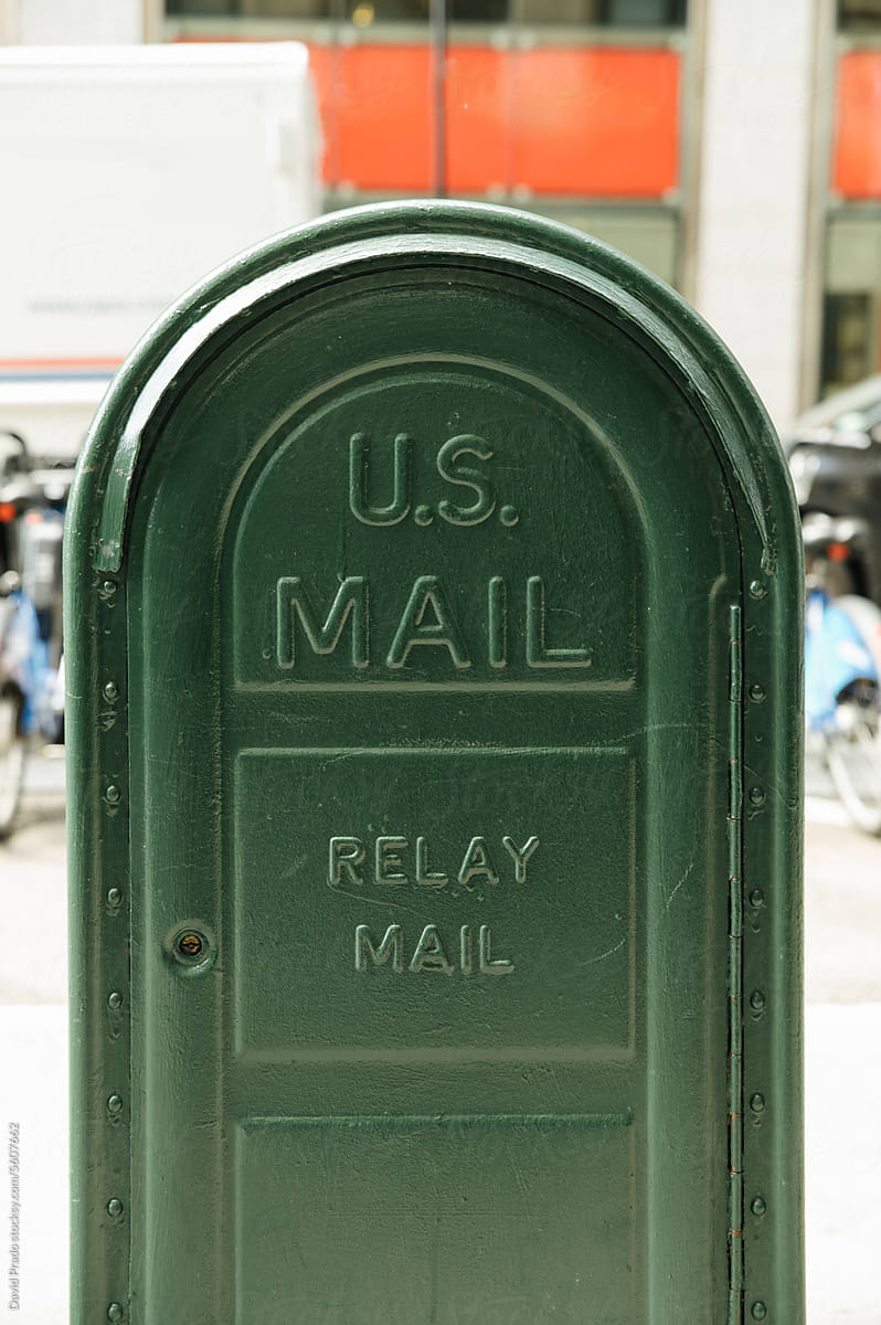 Green metal box with sign US mail on street