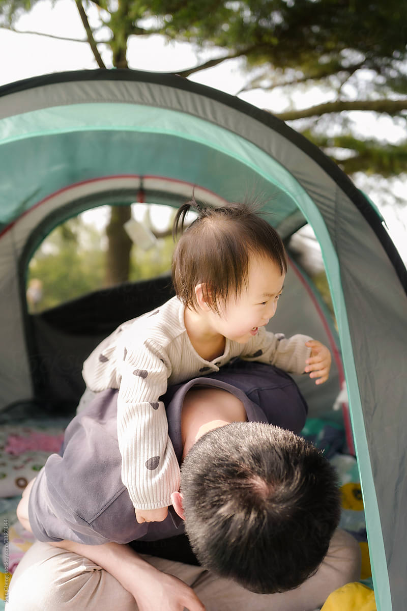 Asian father and daughter in tent