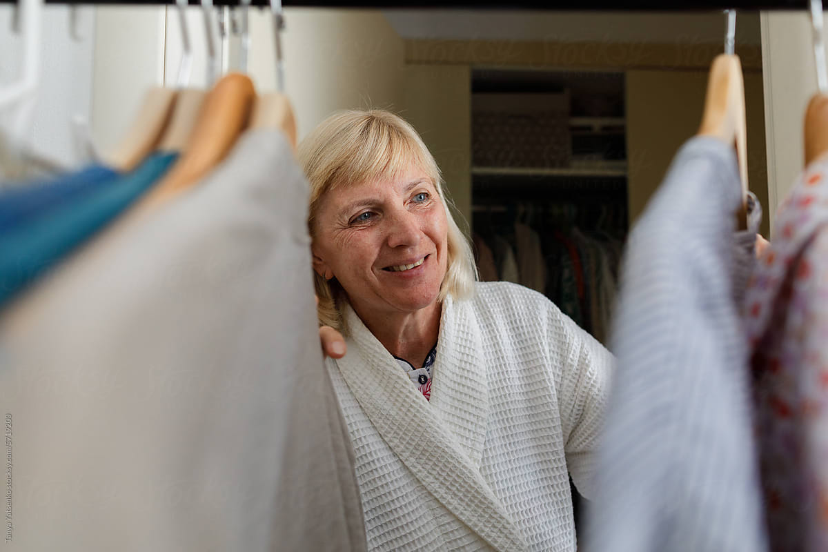 A smiling senior woman choosing clothes to wear