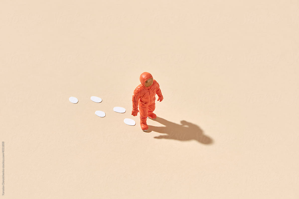 Toy astronaut leaving footprints behind