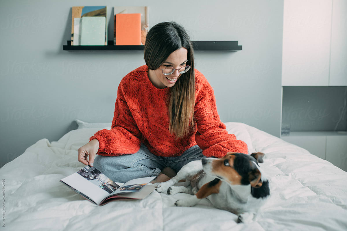 Young Woman Playing With Her Dog and Reading