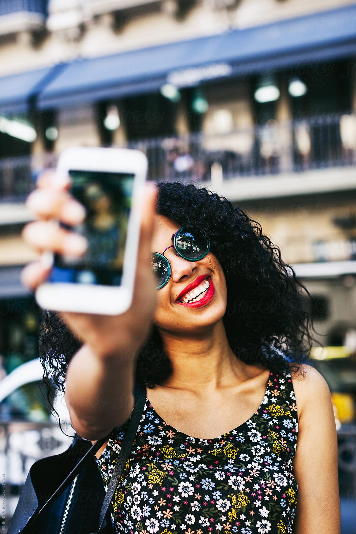 Young Latin Afro Woman Taking A Selfie On Her Smartphone Standing On The Street By Stocksy