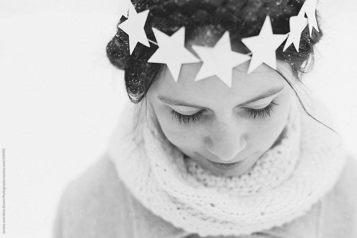 Little girl wearing a star wreath in the snow