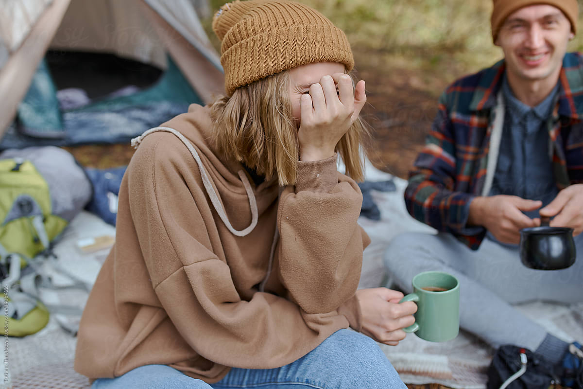 man and woman drink coffee in nature forest park
