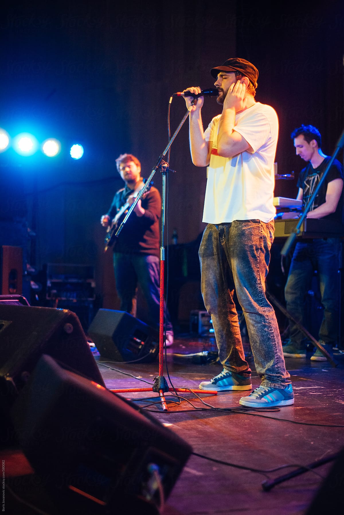 Young man singing on stage with his band