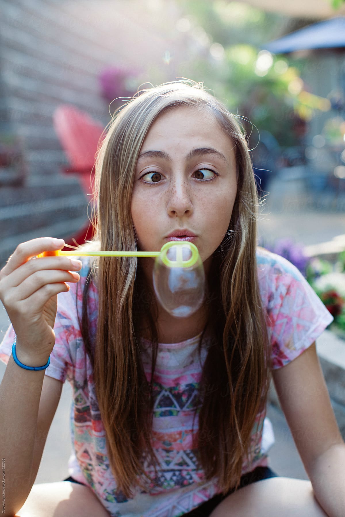 Teenage Girl Blowing Bubbles And Being Silly With Crossed Eyes By Stocksy Contributor Carolyn