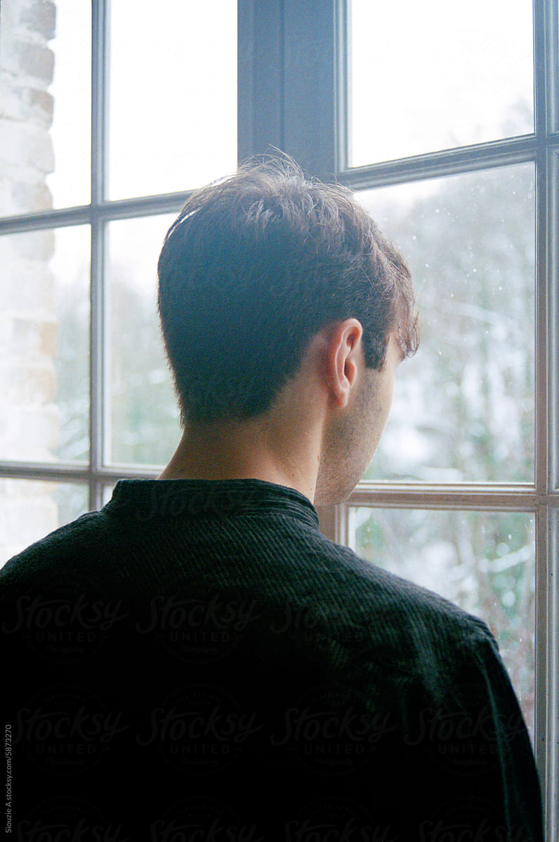 Analog portrait of a young man by the window