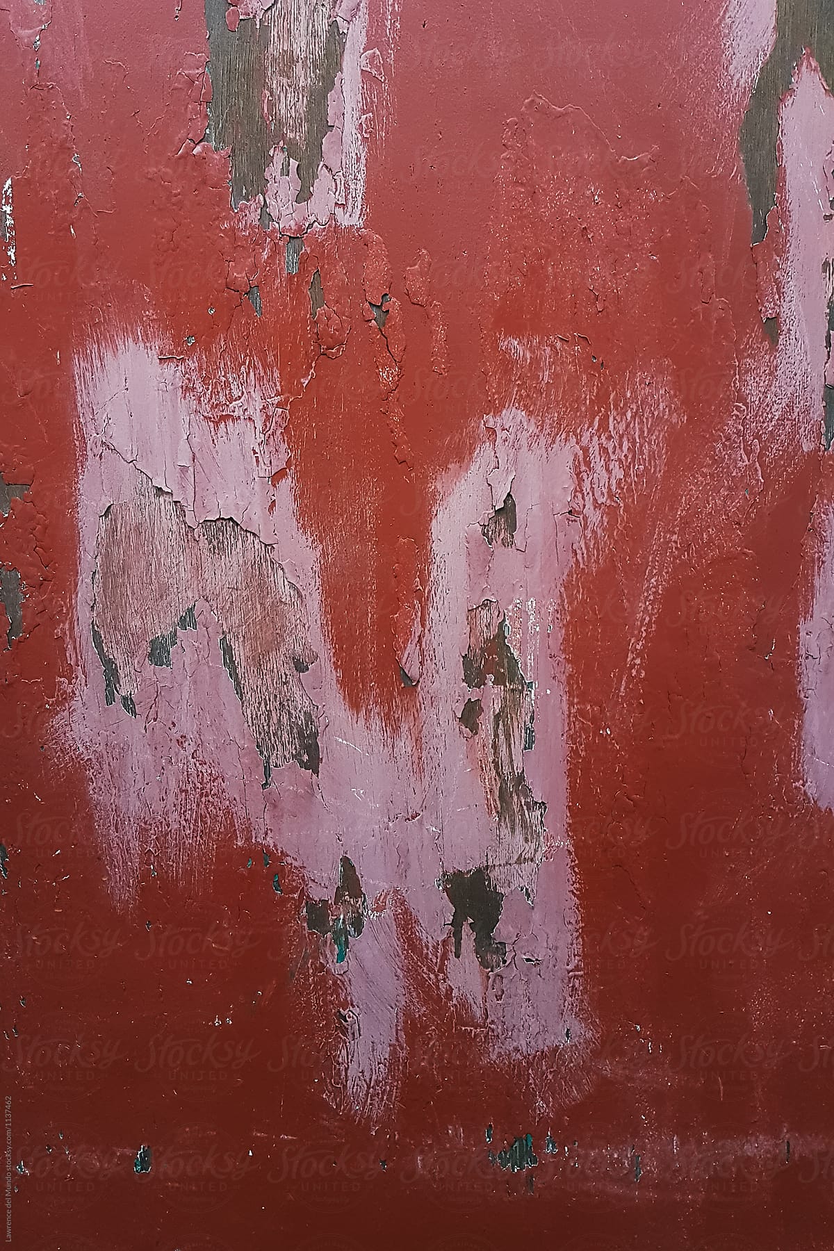 Weathered and decaying paint on a wooden panel of a makeshift wall.