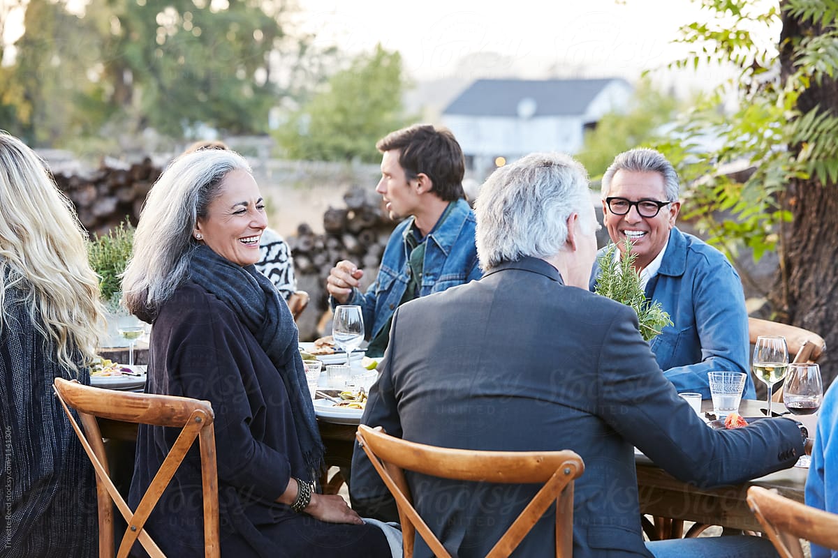 Mature friends at outdoor gathering in backyard