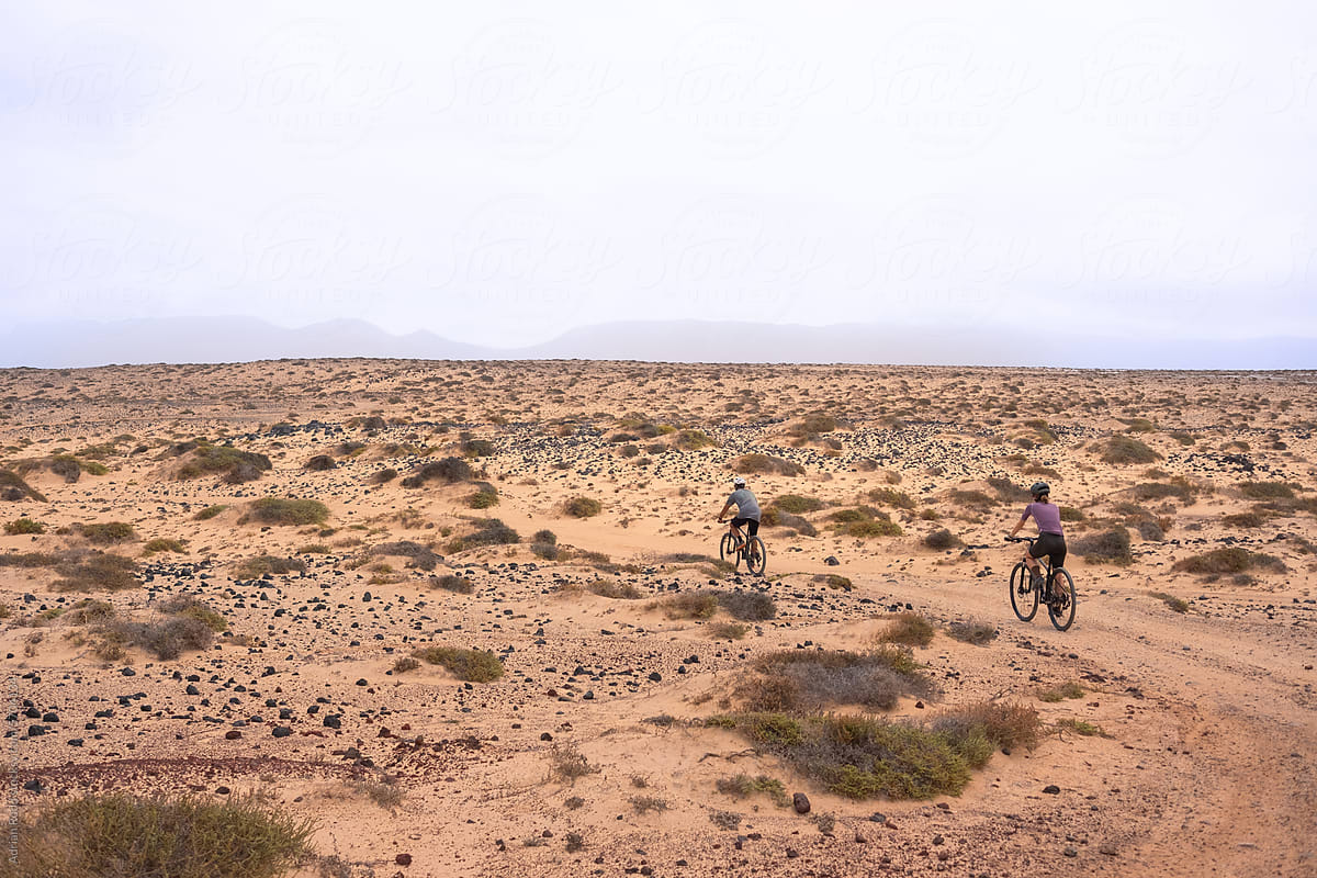 Two cyclists take a ride on the trails of an arid landscape