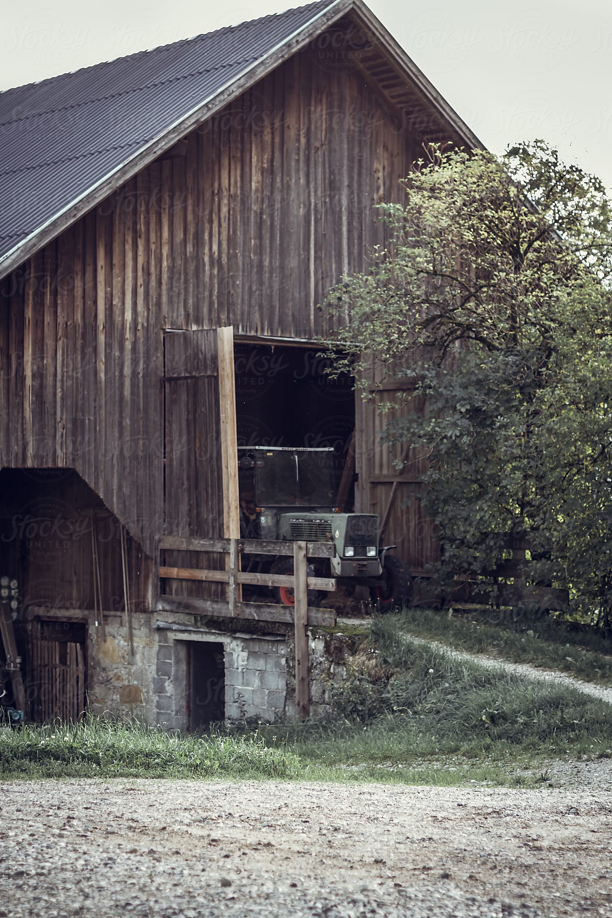 Old wooden farm garage with a tractor