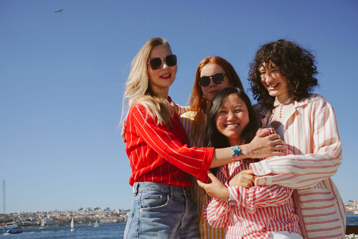 Four young female friends traveling together by the ocean. Feminism