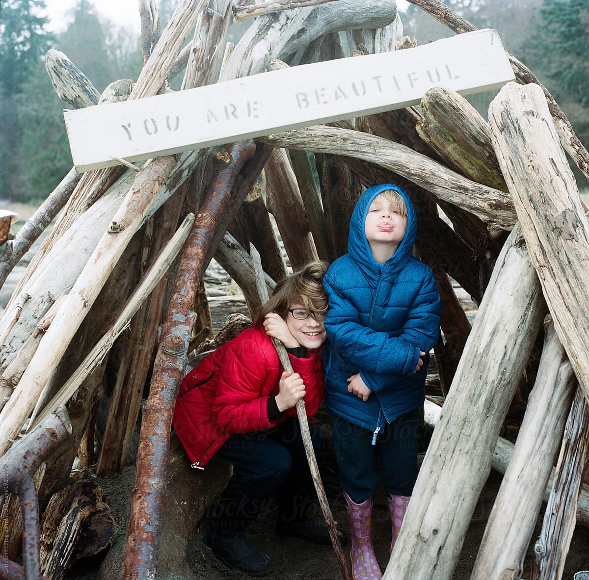 Brothers sharing some time in a driftwood fort