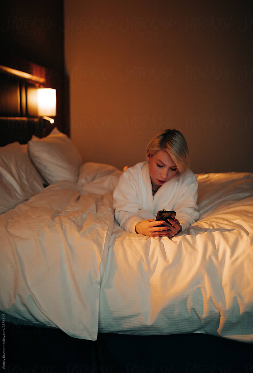young woman  with cell phone on the bed