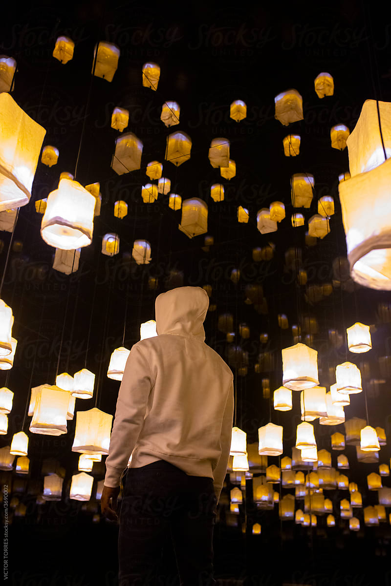 Man in dark room with glowing lanterns