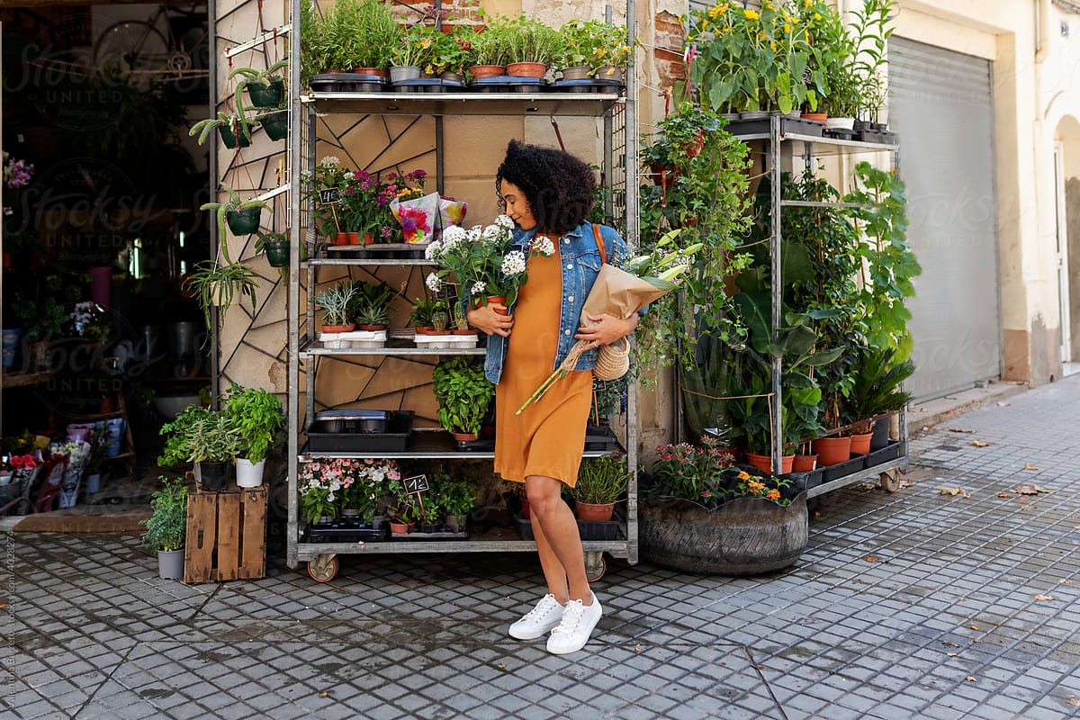 Mixed race woman buying flowers at street flower shop