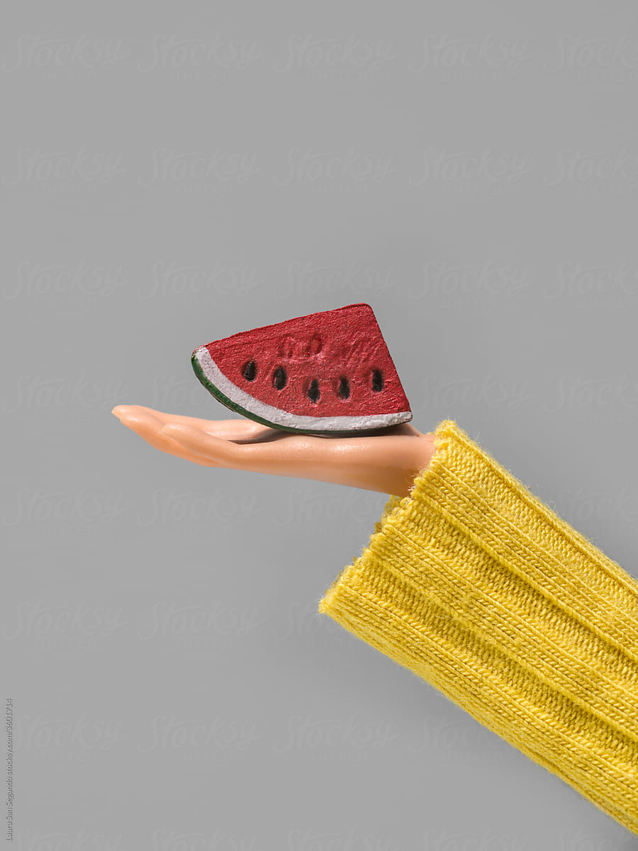 Watermelon slice on a plastic hand