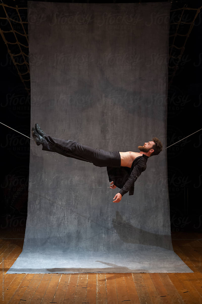 Circus performer lying on a slackwire (wide angle).