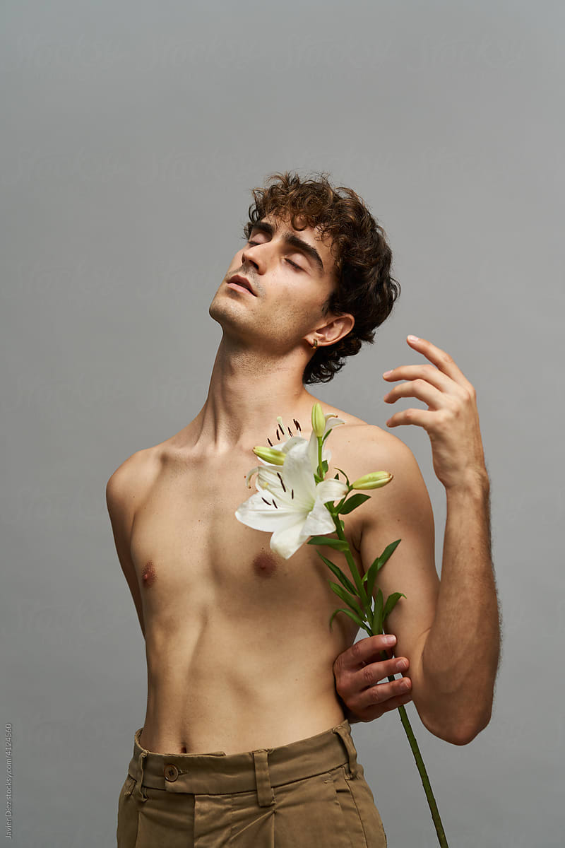 Graceful man with flower in studio