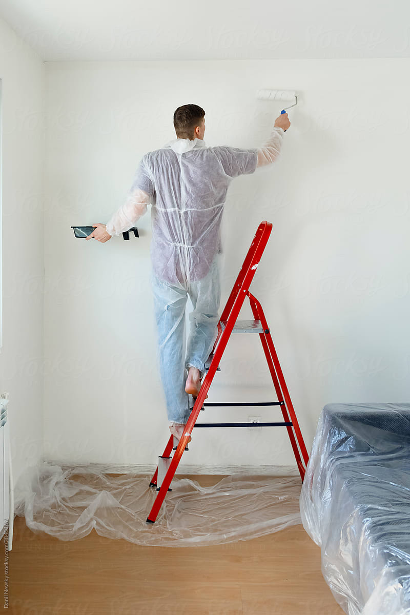 Man renovating and painting walls at home