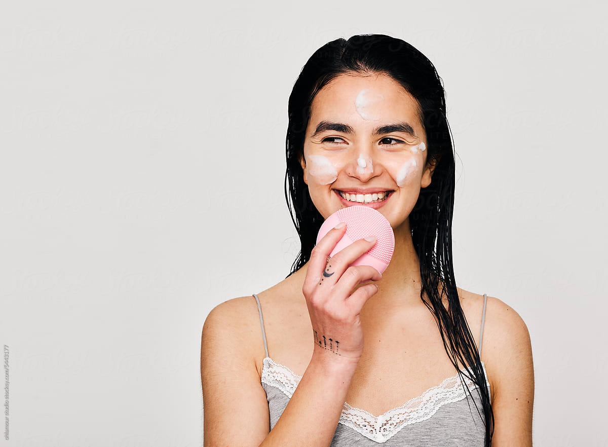 Young black hair woman using foamy face wash and brush