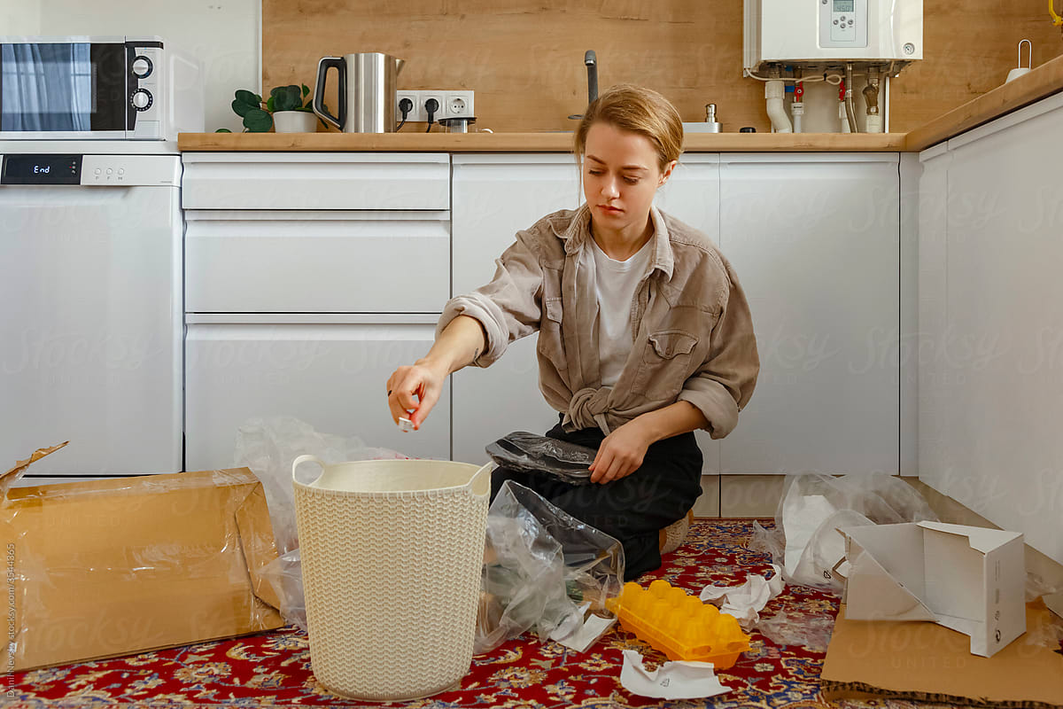 Young woman sorting litter in kitchen