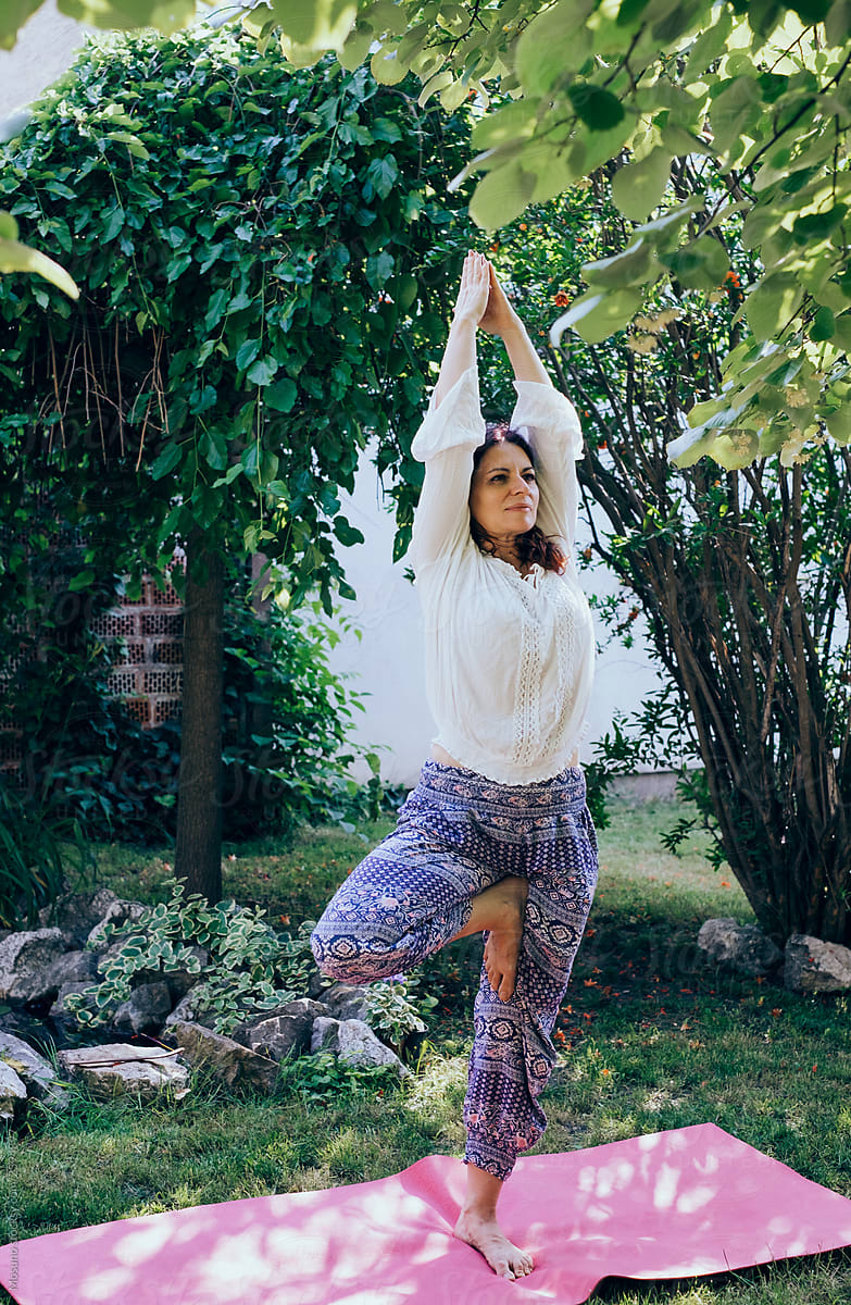 Woman doing yoga in her backyard