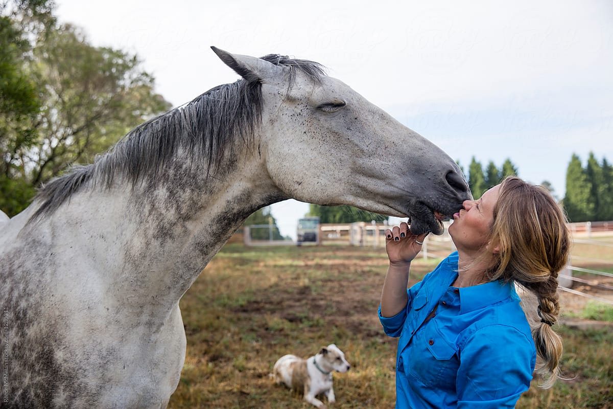 A woman gets hugs and kisses  from her horse