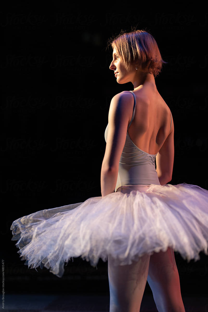 Young ballerina posing in ballet costume standing alone