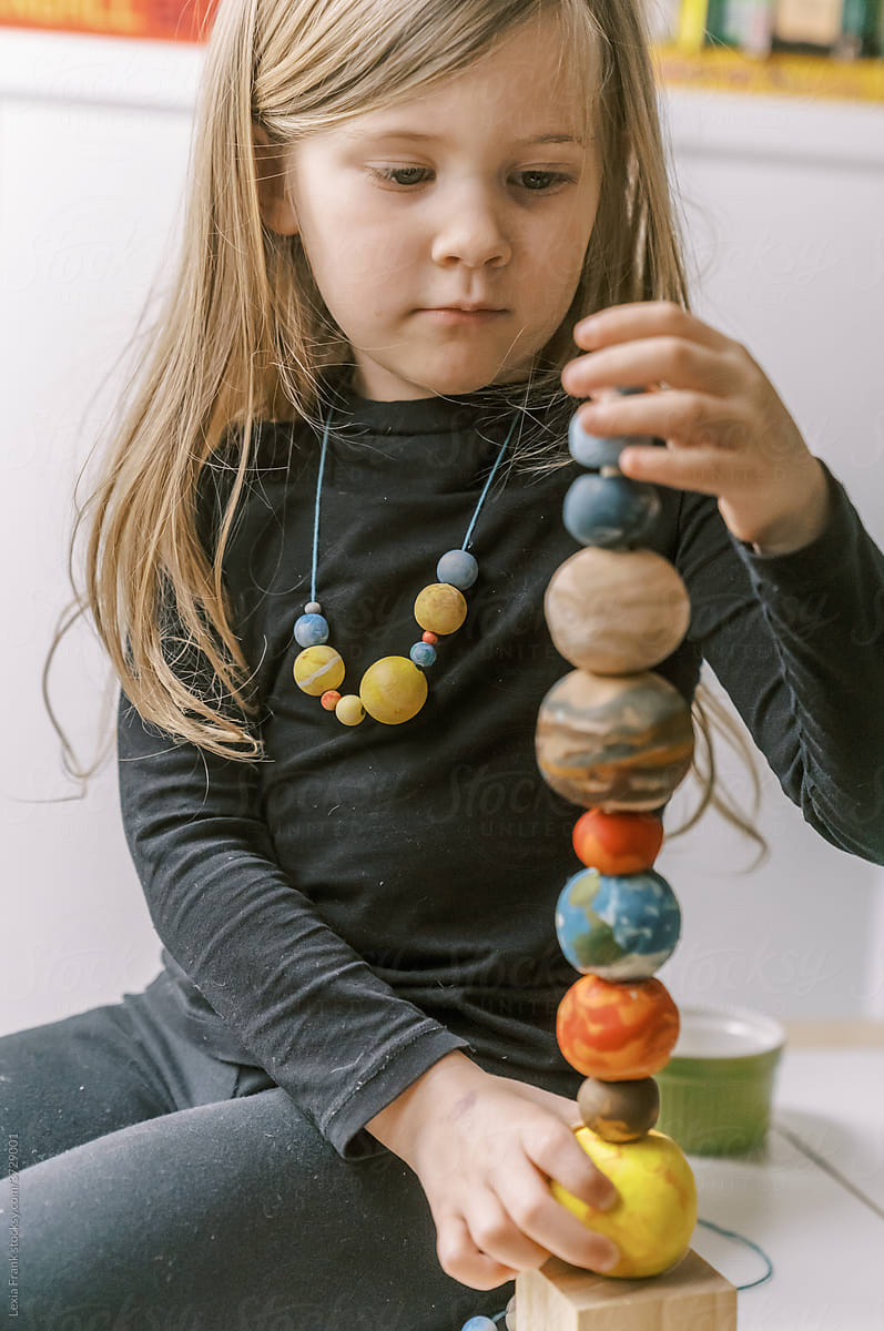 little girl plays with planet stacking toy 2