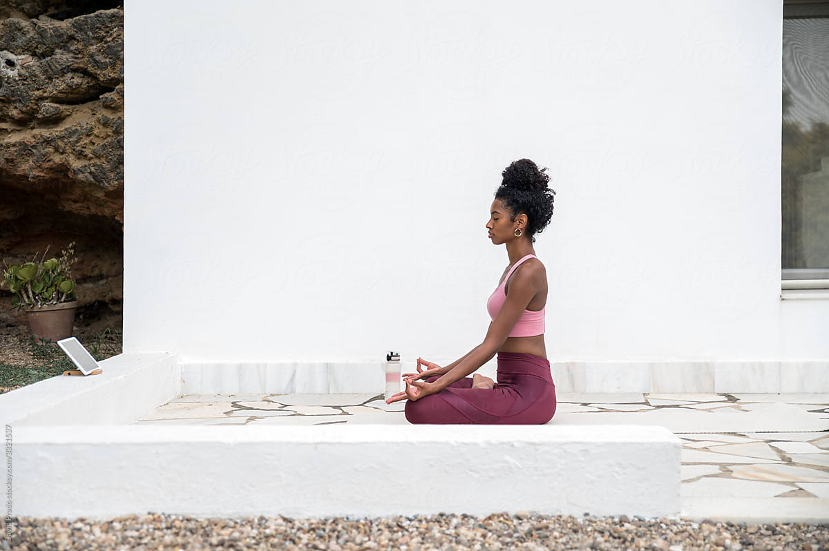 Black woman meditating on porch