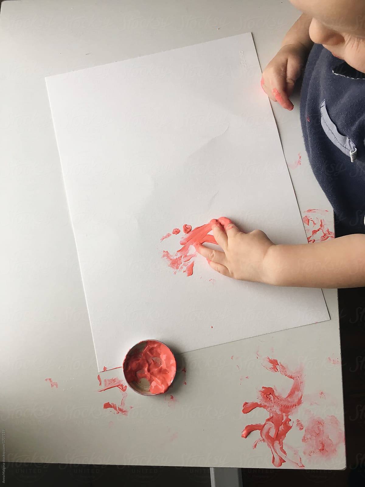 A baby boy painting with hands
