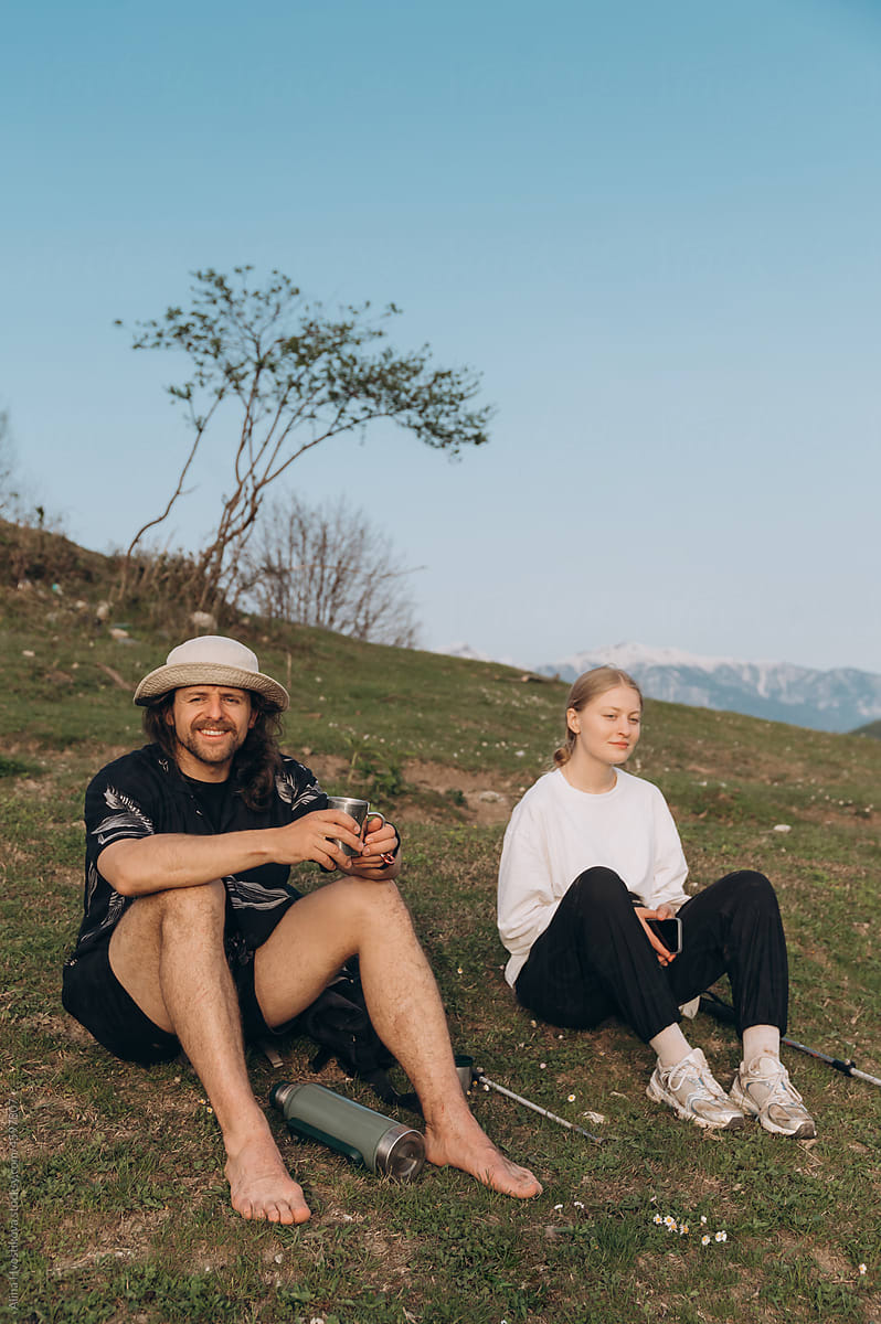 Couple resting on hill in evening