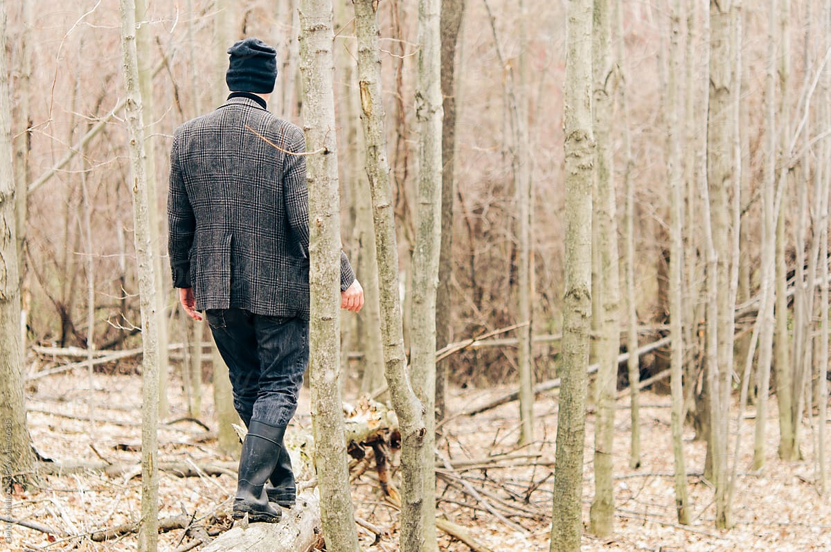 Back of man walking through woods, from behind