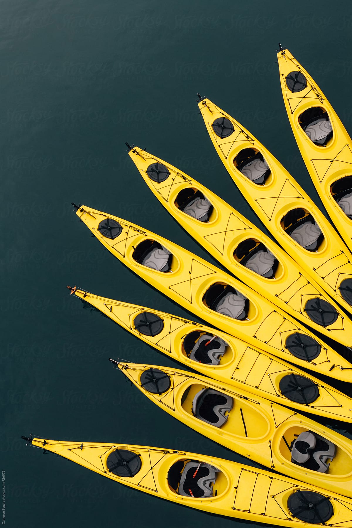 yellow sea kayaks tied together in water