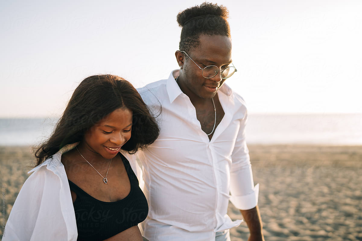 Happy African American couple strolling on beach