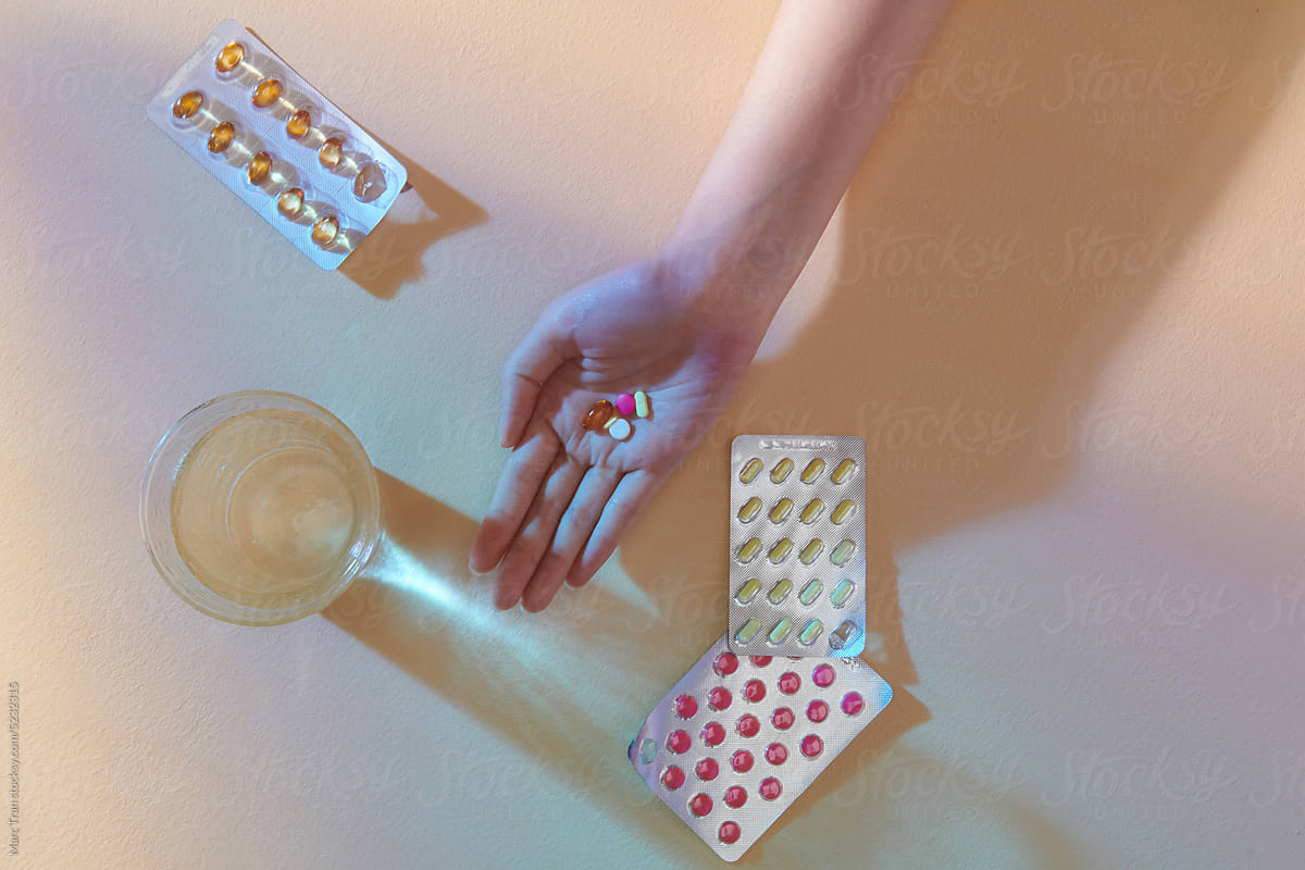 Top view of young hands holding pill, tablet, capsule and glass