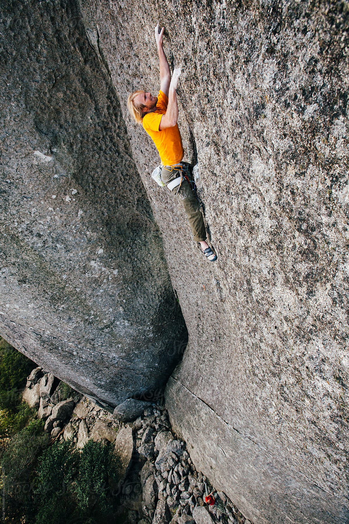 Rock climber climbing an extreme cliff in a mountain